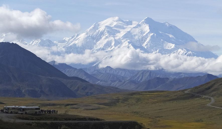 Sightseeing buses and tourists are seen at a pullout popular for taking in views of North America's tallest peak, Denali, in Denali National Park and Preserve, Alaska, Aug. 26, 2016. Two climbers awaited rescue near the peak of North America’s tallest mountain Wednesday, May 29, 2024, a day after they and a third climber in their team requested help after summiting Denali during the busiest time of the mountaineering season, officials at Denali National Park and Preserve said. (AP Photo/Becky Bohrer, File)