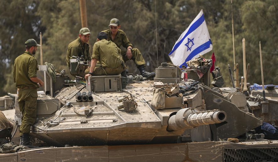 Israeli soldiers work on a tank near the Israeli-Gaza border, in southern Israel, Wednesday, May 29, 2024. (AP Photo/Tsafrir Abayov)