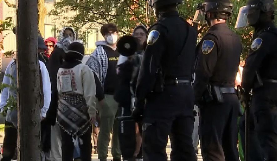 In this image made from video provided by WXYZ, police stand guard after they dismantled a pro-Palestinian encampment at Wayne State University in Detroit on Thursday, May 30, 2024. The police action came two days after the school suspended in-person classes and encouraged staff to work remotely to avoid any problems with the protesters' encampment. (WXYZ via AP)