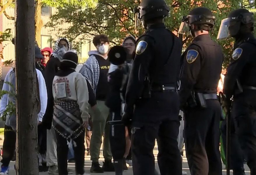 In this image made from video provided by WXYZ, police stand guard after they dismantled a pro-Palestinian encampment at Wayne State University in Detroit on Thursday, May 30, 2024. The police action came two days after the school suspended in-person classes and encouraged staff to work remotely to avoid any problems with the protesters' encampment. (WXYZ via AP)