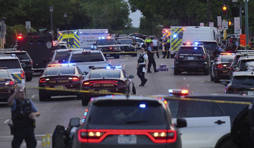 Investigators examine the scene of a shooting Thursday, May 30, 2024, in Minneapolis. Two Minneapolis police officers and four civilians were injured in south Minneapolis, Thursday in what officials are calling an active-shooter situation, law enforcement said. (Glen Stubbe/Star Tribune via AP)