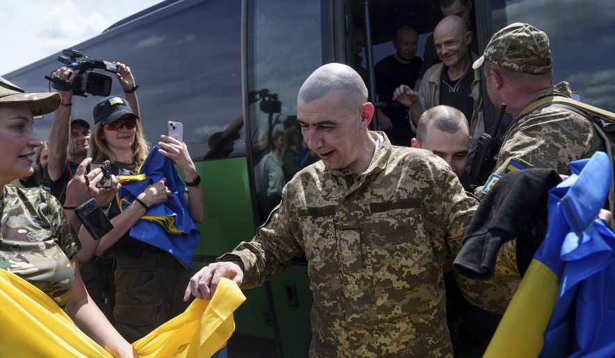 A Ukrainian serviceman reacts after returning from captivity during POWs exchange in Sumy region, Ukraine, Friday, May 31, 2024. Ukraine returned 75 prisoners, including four civilians, in the latest exchange of POWs with Russia. It's the fourth prisoner swap this year, and 52nd since Russia invaded Ukraine. In all, 3 210 Ukrainian servicemen and civilians were returned since the outbreak of the war. (AP Photo/Evgeniy Maloletka)