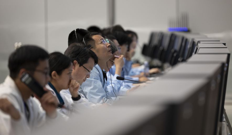 In this photo released by Xinhua News Agency, technical personnel work at the Beijing Aerospace Control Center (BACC) in Beijing, Sunday, June 2, 2024. A Chinese spacecraft landed on the far side of the moon Sunday to collect soil and rock samples that could provide insights into differences between the less-explored region and the better-known near side. (Jin Liwang/Xinhua via AP)