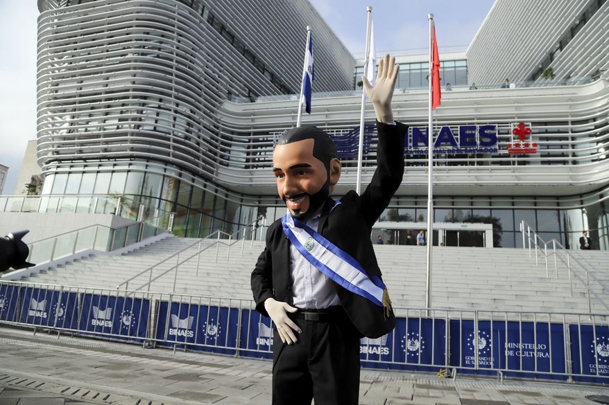 A supporter of El Salvador's President Nayib Bukele, wearing a mask depicting him, poses for a photo outside the National Library prior to his inauguration for a second term in San Salvador, El Salvador, Saturday, June 1, 2024. (AP Photo/Salvador Melendez)