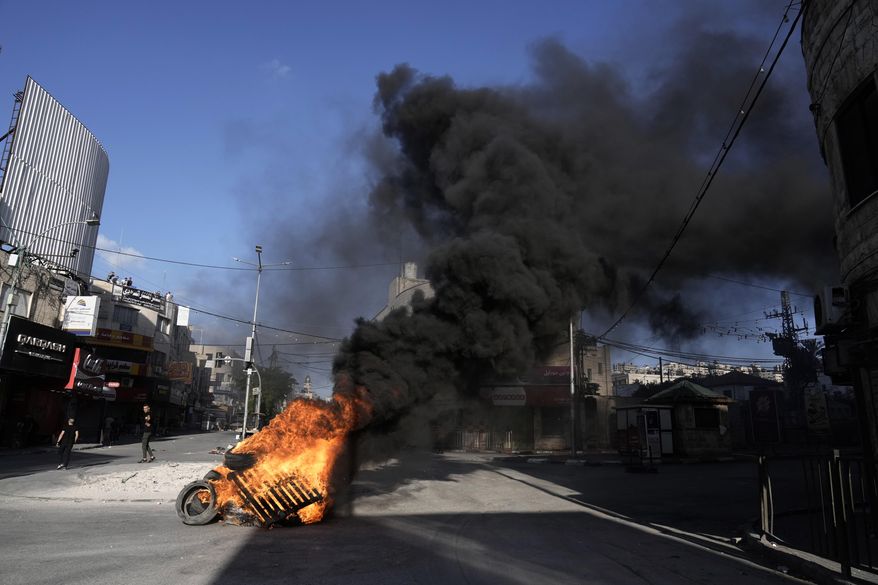 Tires burn as Israeli forces Israeli forces operate in the Balata refugee camp, in the West Bank city of Nablus, Saturday, June 1, 2024. The Israeli military said that its forces conducted counterterrorism activity in the area overnight. (AP Photo/Majdi Mohammed)