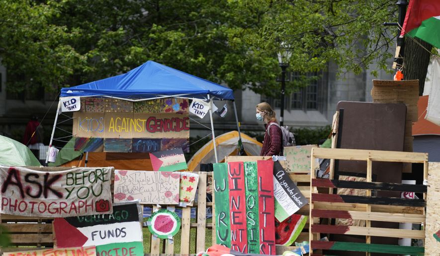 A student walks in a pro-Palestinian encampment at Main Quadrangle on the University of Chicago campus Monday, May 6, 2024, in Chicago. (AP Photo/Nam Y. Huh, File)