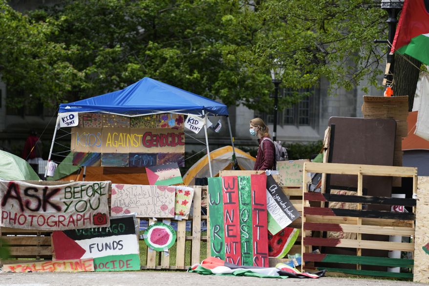 A student walks in a pro-Palestinian encampment at Main Quadrangle on the University of Chicago campus Monday, May 6, 2024, in Chicago. (AP Photo/Nam Y. Huh, File)
