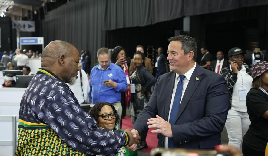 Leader of the main opposition Democratic Alliance John Steenhuisen, right, shakes hands with ANC's Chairman. Gwede Mantashe, left, on a visit to the Results Operation Centre (ROC) in Midrand, Johannesburg, South Africa, Friday May 31, 2024. South Africa is heading closer to the reality of a national coalition government for the first time as partial election results put the ruling African Nation Congress (ANC), short of a majority. (AP Photo/Themba Hadebe)