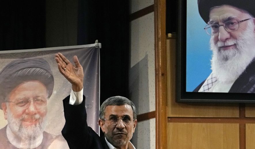 Iran's hard-line former President Mahmoud Ahmadinejad waves to the media as he leaves at the conclusion of a press briefing beside portraits of the Supreme Leader Ayatollah Ali Khamenei, top right, and the late President Ebrahim Raisi after registering his name as a candidate for the June 28 presidential election at the Interior Ministry, in Tehran, Iran, Sunday, June 2, 2024. Ahmadinejad registered Sunday as a possible candidate for the presidential election, seeking to regain the country's top political position after a helicopter crash killed the nation's president. (AP Photo/Vahid Salemi)