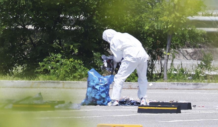 An officer wearing protective gear collects the trash from a balloon presumably sent by North Korea, in Siheung, South Korea, Sunday, June 2, 2024. South Korea said Sunday it’ll take strong retaliatory steps against North Korea over its launch of trash-carrying balloons and other provocations on South Korea. (Hong Ki-won/Yonhap via AP)