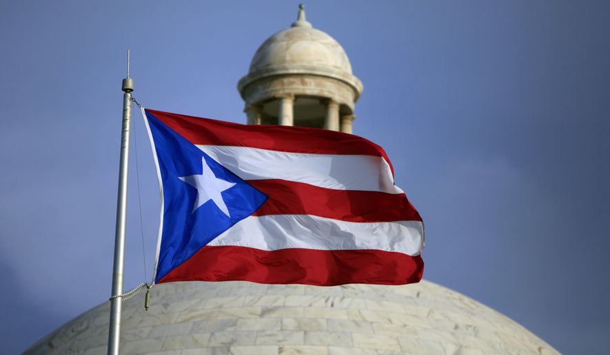 FILE - A Puerto Rican national flag flies in front of the Capitol building in San Juan, Puerto Rico, July 29, 2015. The island’s two biggest political parties hold gubernatorial primaries on Sunday, June 2, 2024. (AP Photo/Ricardo Arduengo, File)