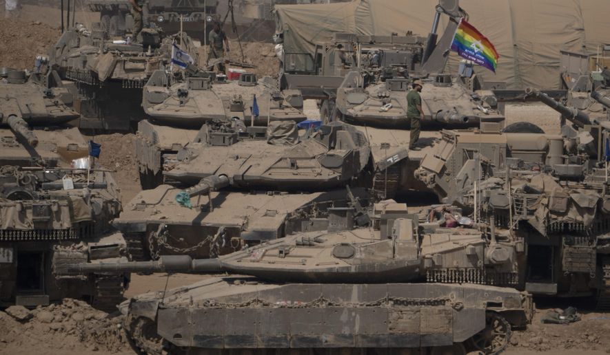 Israeli soldiers stand on top of tanks in a staging area near the Israeli-Gaza border in southern Israel, Monday, June 3, 2024. (AP Photo/Leo Correa)