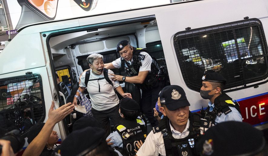 Police officers detained a resident in Causeway Bay area on the 35th anniversary of China's Tiananmen Square crackdown, in Hong Kong, Tuesday, June 4, 2024. (AP Photo/Chan Long Hei)