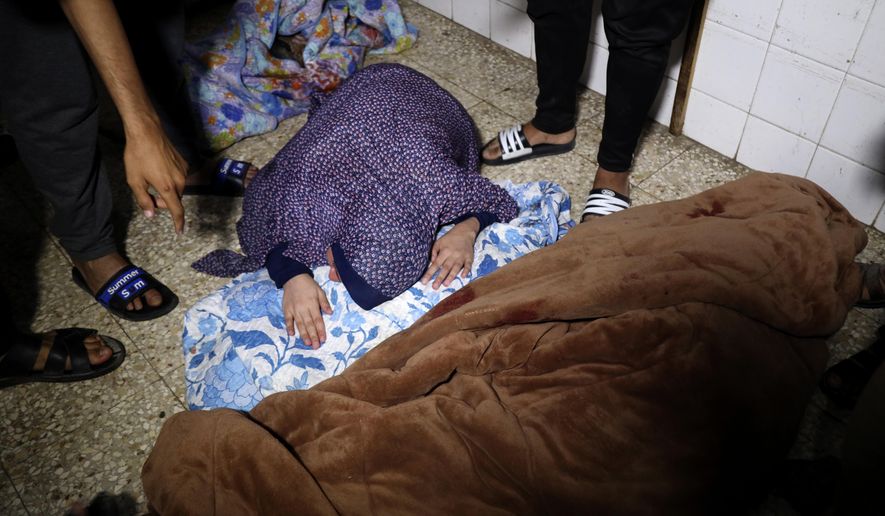 A Palestinian woman mourns her relative, a child of Rewan Ghanem, killed in an Israeli bombardment on a residential building owned by the Ghanem family in Bureij refugee camp, at al-Aqsa Martyrs hospital in Deir al-Balah, central Gaza Strip, late Monday, June 3, 2024. (AP Photo/Saher Alghorra)