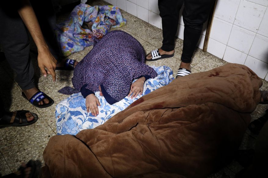A Palestinian woman mourns her relative, a child of Rewan Ghanem, killed in an Israeli bombardment on a residential building owned by the Ghanem family in Bureij refugee camp, at al-Aqsa Martyrs hospital in Deir al-Balah, central Gaza Strip, late Monday, June 3, 2024. (AP Photo/Saher Alghorra)
