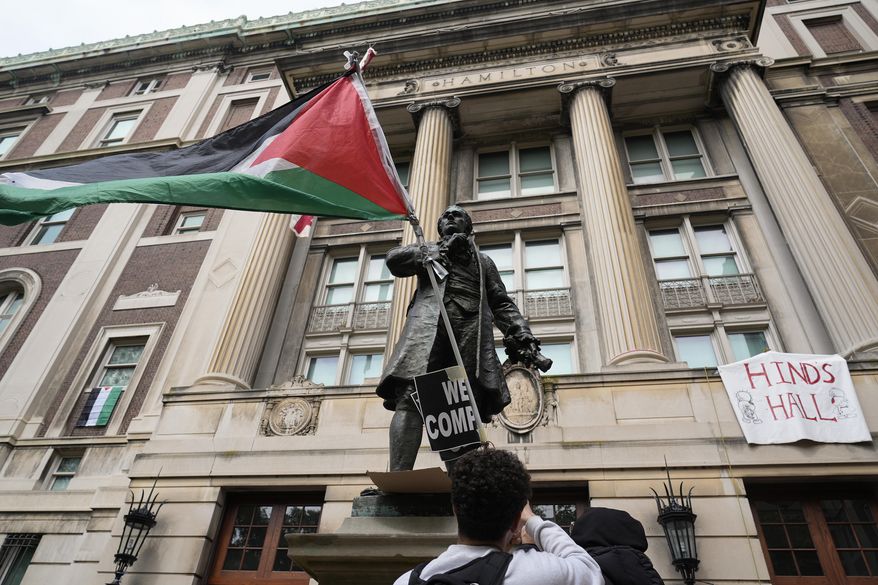 A student protester parades a Palestinian flag outside the entrance to Hamilton Hall on the campus of Columbia University, Tuesday, April 30, 2024, in New York. The student-run legal journal, Columbia Law Review, was taken offline Monday, June 3, 2024, after its board of directors objected to the publication of an article that accused Israel of genocide. (AP Photo/Mary Altaffer, Pool) **FILE**
