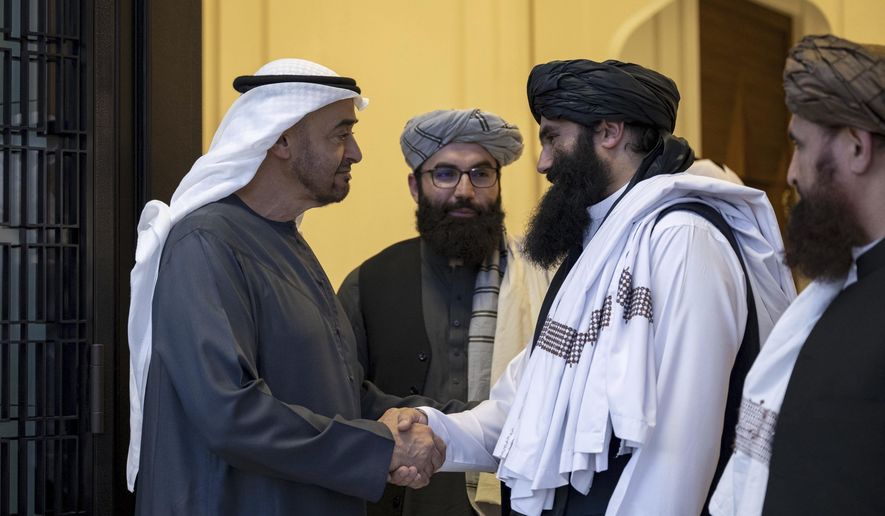 In this photograph released by the state-run WAM news agency, Emirati leader Sheikh Mohammed bin Zayed Al Nahyan, ruler of Abu Dhabi, left, shakes hands with Taliban official Sirajuddin Haqqani at Qasr Al Shati palace in Abu Dhabi, United Arab Emirates, Tuesday, June 4, 2024. The leader of the United Arab Emirates met Tuesday with an official in the Taliban government still wanted by the U.S. on an up-to $10 million bounty over his involvement in an attack that killed an American citizen and other assaults. (WAM via AP)