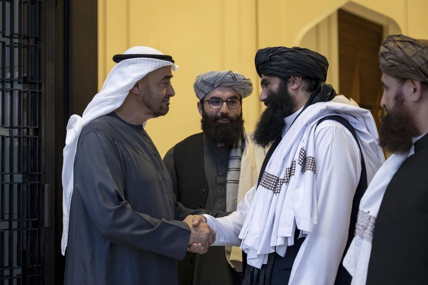 In this photograph released by the state-run WAM news agency, Emirati leader Sheikh Mohammed bin Zayed Al Nahyan, ruler of Abu Dhabi, left, shakes hands with Taliban official Sirajuddin Haqqani at Qasr Al Shati palace in Abu Dhabi, United Arab Emirates, Tuesday, June 4, 2024. The leader of the United Arab Emirates met Tuesday with an official in the Taliban government still wanted by the U.S. on an up-to $10 million bounty over his involvement in an attack that killed an American citizen and other assaults. (WAM via AP)