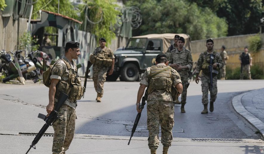 Lebanese security stand guard on a road that leads to the U.S. Embassy in Aukar, a northern suburb of Beirut, Lebanon, Wednesday, June 5, 2024. A gunman was captured by Lebanese soldiers after attempting to attack the U.S. Embassy near Beirut on Wednesday, the military said. (AP Photo/Bilal Hussein)