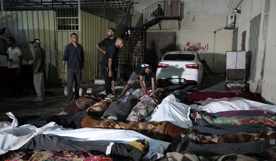 Palestinians check the bodies of their relatives killed in an Israeli bombardment of UNRWA school at Nusseirat refugee camp, in front of the morgue of al-Aqsa Martyrs hospital in Deir al-Balah, central Gaza Strip, early Thursday, June 6, 2024. (AP Photo/Abdel Kareem Hana)
