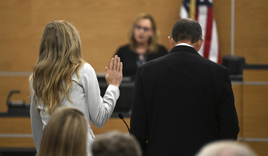 Molly Corbett, left, swears on the Bible as she pleads no contest to voluntary manslaughter in the 2015 death of her husband, Jason Corbett, during a hearing, Oct. 30, 2023, at the Davidson County Courthouse in Lexington, N.C. Molly Corbett and her father, Thomas Martens, were released from separate North Carolina prisons Thursday, June 6, 2024, after completing the tail end of their sentences for pleas to voluntary manslaughter. (Walt Unks/The Winston-Salem Journal via AP, Pool, File)