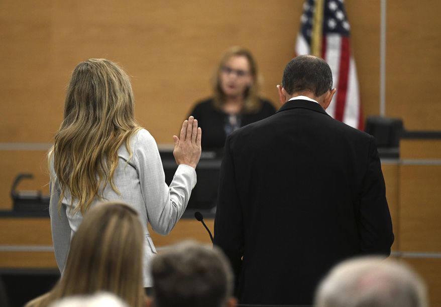Molly Corbett, left, swears on the Bible as she pleads no contest to voluntary manslaughter in the 2015 death of her husband, Jason Corbett, during a hearing, Oct. 30, 2023, at the Davidson County Courthouse in Lexington, N.C. Molly Corbett and her father, Thomas Martens, were released from separate North Carolina prisons Thursday, June 6, 2024, after completing the tail end of their sentences for pleas to voluntary manslaughter. (Walt Unks/The Winston-Salem Journal via AP, Pool, File)