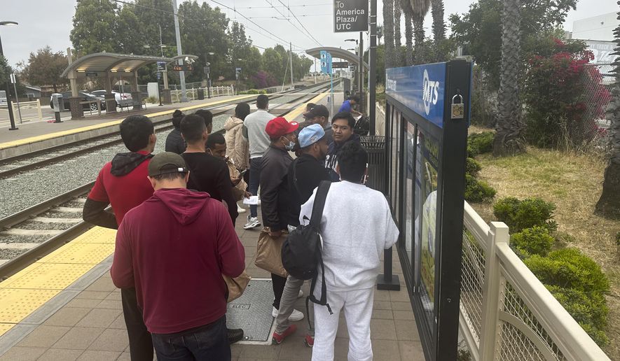 Migrants released with notices to appear in immigration court wait for a train to the San Diego International Airport in San Diego, Calif., Thursday, June 6, 2024. (AP Photo/Elliot Spagat) ** FILE **