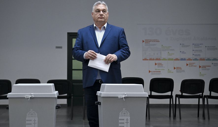 Hungarian Prime Minister Viktor Orban, leader of the ruling Fidesz party prepares to cast his vote at a polling station during the European Parliament and the local elections in Budapest, Hungary, Sunday June 9, 2024. (Szilard Koszticsak/MTI via AP)