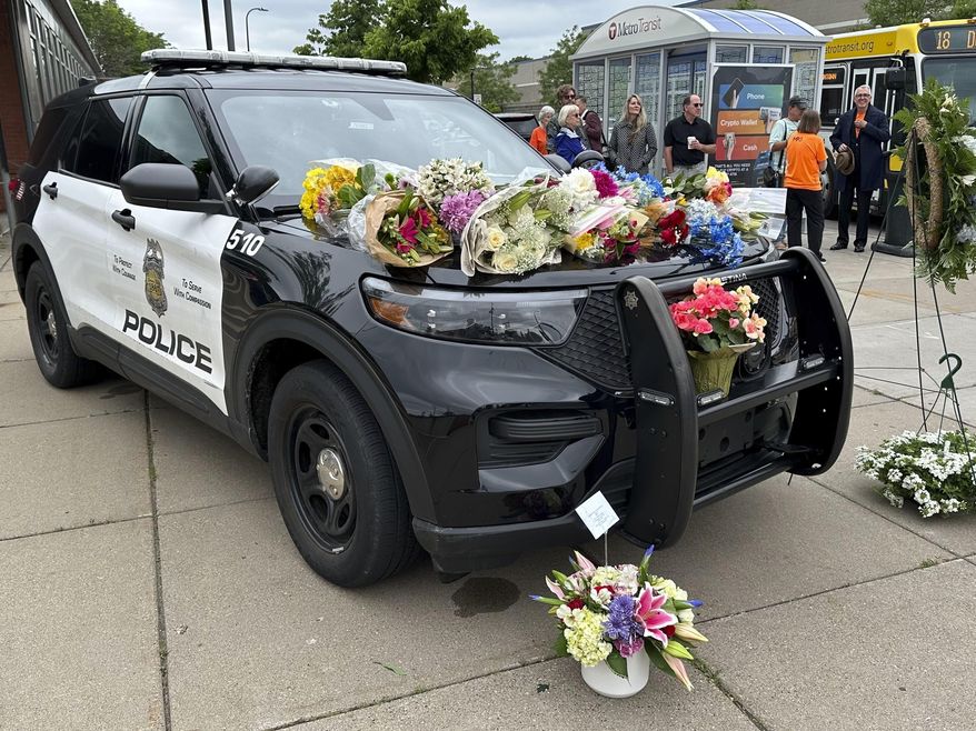 Mourners leave flowers on a police car at a precinct, May 31, 2024, a day after an officer and two others were killed in a shooting. A fourth person has died from injuries sustained in a late May mass shooting in Minneapolis that also killed a police officer. Mohamed Aden, 36, of Columbia Heights, died Friday from complications of multiple gunshot wounds he sustained in the May 30 shooting, the Hennepin County Medical Examiner’s Office said Sunday, June 9 in a news release. (AP Photo/Mark Vancleave, file)