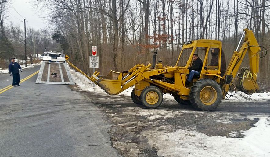 FBI investigators remove a backhoe seized from the Crawford, N.Y., property of former Briarcliff Manor Police officer Nicholas Tartaglione, Dec. 21, 2016. Tartaglione will serve life in prison for overseeing the murder of four people, including a man he tortured and killed over stolen drug money, prosecutors said. He was sentenced Monday, June 10, 2024, to four consecutive life sentences. (James Nani/Times Herald-Record via AP, File)