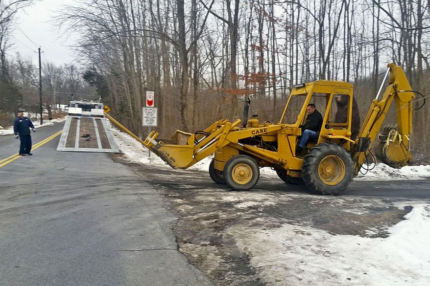 FBI investigators remove a backhoe seized from the Crawford, N.Y., property of former Briarcliff Manor Police officer Nicholas Tartaglione, Dec. 21, 2016. Tartaglione will serve life in prison for overseeing the murder of four people, including a man he tortured and killed over stolen drug money, prosecutors said. He was sentenced Monday, June 10, 2024, to four consecutive life sentences. (James Nani/Times Herald-Record via AP, File)