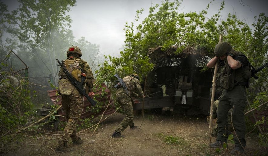 In this photo taken on Friday, April 26, 2024 and released by the Russian Defense Ministry Press Service, Russian soldiers fire a 2A65 "Msta-B" howitzer in an undisclosed location in Ukraine. (Russian Defense Ministry Press Service via AP)