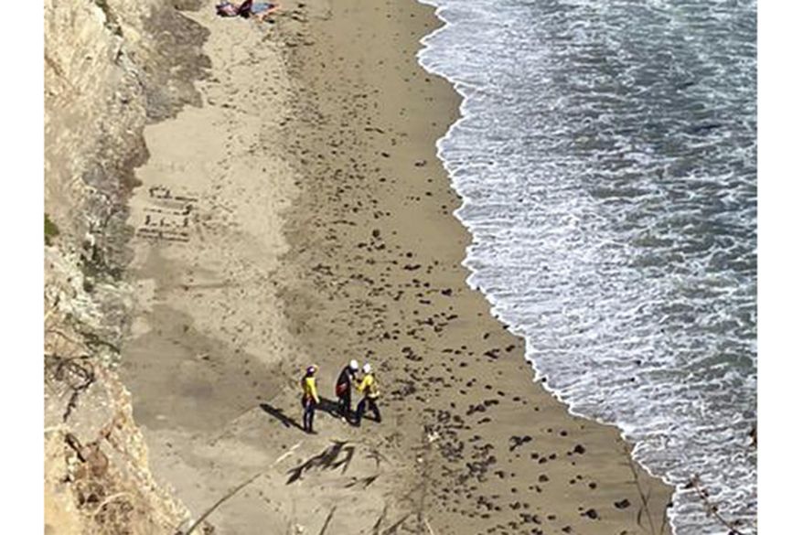 This photo taken by Cal Fire CZU, shows the scene of the rescue of a kite surfer on a beach under a cliff off the coast near Santa Cruz, Calif. Sunday, June 9, 2024. The surfer was spotted by rescue crews after they spelled out the word "help" on the beach using rocks. (Cal Fire CZU via AP)