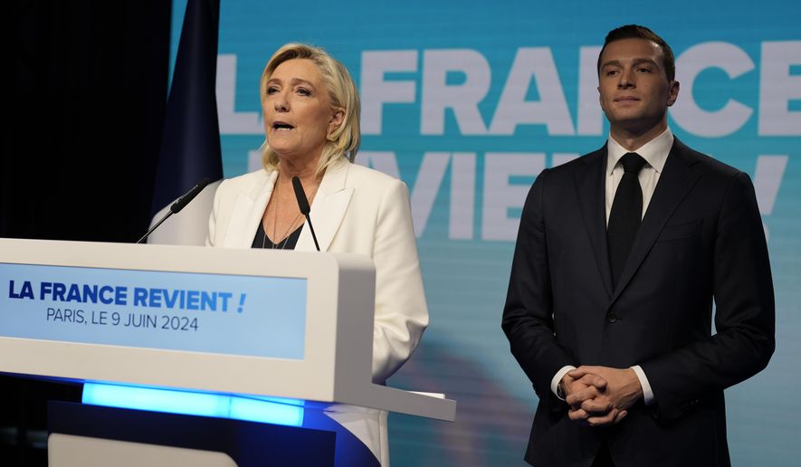 French far-right leader Marine Le Pen delivers a speech as Jordan Bardella, president of the French far-right National Rally, listens at the party election night headquarters after French President Emanuel Macron announced he dissolves National Assembly and calls new legislative election after defeat in EU vote, Sunday, June 9, 2024 in Paris. First projected results from France put far-right National Rally party well ahead in EU elections, according to French opinion poll institutes. (AP Photo/Lewis Joly)