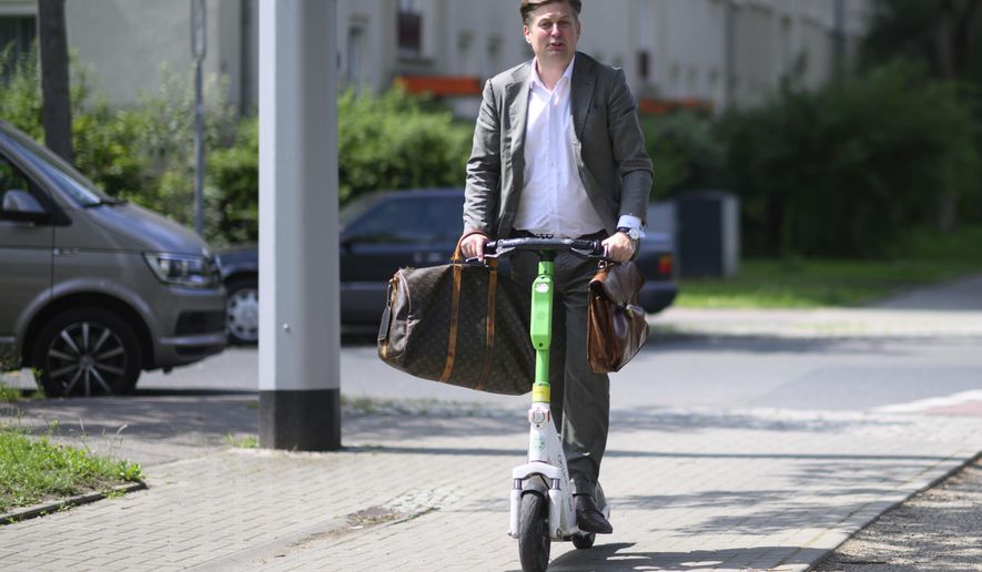 Far-right Alternative for Germany (AfD) top candidate for the European Parliament elections Maximilian Krah leaves a polling station on an e-scooter after casting his vote in the European and local elections in Dresden, Germany, Sunday, June 9, 2024. (Robert Michael/dpa via AP)