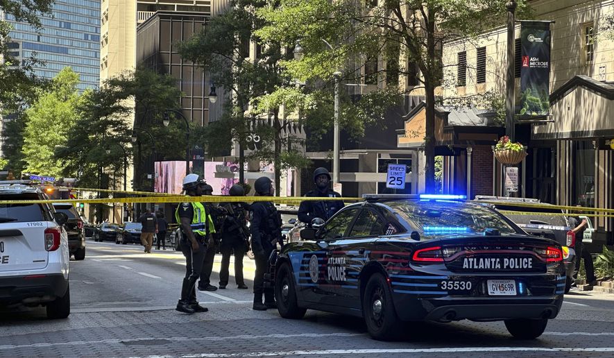 Police respond to the scene of a shooting outside the Peachtree Center complex, Tuesday, June 11, 2024, in downtown Atlanta. (AP Photo/Jeff Amy)