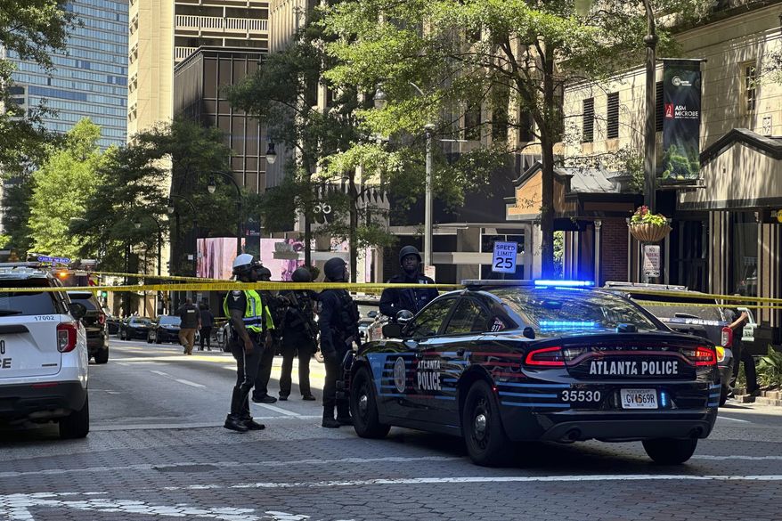 Police respond to the scene of a shooting outside the Peachtree Center complex, Tuesday, June 11, 2024, in downtown Atlanta. (AP Photo/Jeff Amy)