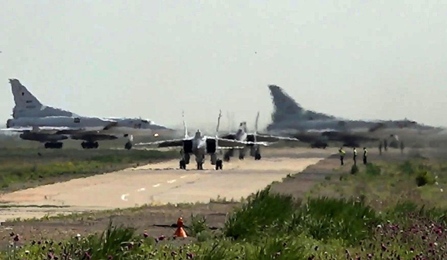 In this photo taken from video on Monday, June 10, 2024, and released by the Russian Defense Ministry Press Service, A pair of MiG-31 fighter jets of the Russian air force taxi out for a training mission with two Tu-22M3 bombers seen in the background during joint Russian-Belarusian drills intended to train the military to use tactical nuclear weapons. (Russian Defense Ministry Press Service via AP)