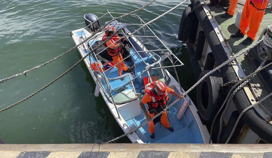 In this photo released by the Taiwan Coast Guard, Taiwan's coast guard officials are seen on board a speedboat that an alleged former Chinese naval officer used to enter a harbor in New Taipei city, Taiwan on Monday, June 10, 2024. Taiwanese authorities are investigating how the Chinese man had driven the small boat into a strategic river mouth that leads to the capital of the self-governing island republic. (Taiwan Coast Guard via AP)