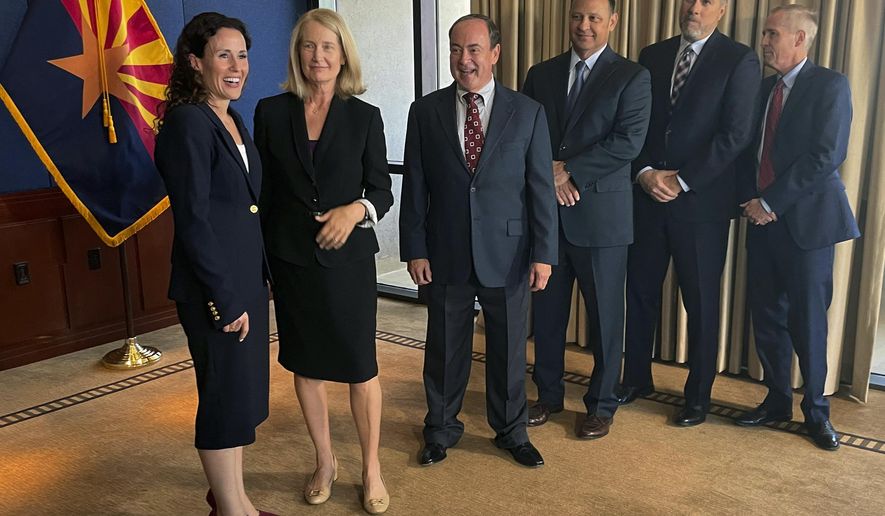FILE - Kathryn Hackett King, left, speaks with Arizona Supreme Court justices before taking the oath of office to join the state's high court, July 8, 2021, in Phoenix. From left to right are: Hackett King, Vice Chief Justice Ann A. Scott Timmer, Justices Clint Bolick, John R Lopez IV, James Beene and Chief Justice Robert M. Brutinel. The Arizona Legislature voted Wednesday, June 12, 2024, to send an initiative to the November ballot that would protect Justices Hackett King and Bolick, targeted for removal from the bench over support for a near-total abortion ban dating back to the Civil War. (AP Photo/Jonathan J. Cooper, File)