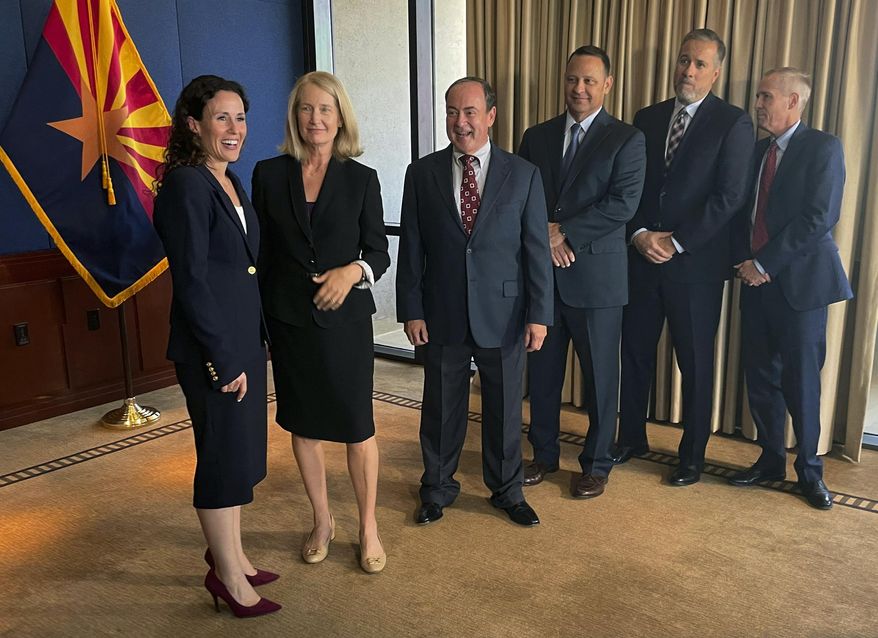 FILE - Kathryn Hackett King, left, speaks with Arizona Supreme Court justices before taking the oath of office to join the state's high court, July 8, 2021, in Phoenix. From left to right are: Hackett King, Vice Chief Justice Ann A. Scott Timmer, Justices Clint Bolick, John R Lopez IV, James Beene and Chief Justice Robert M. Brutinel. The Arizona Legislature voted Wednesday, June 12, 2024, to send an initiative to the November ballot that would protect Justices Hackett King and Bolick, targeted for removal from the bench over support for a near-total abortion ban dating back to the Civil War. (AP Photo/Jonathan J. Cooper, File)