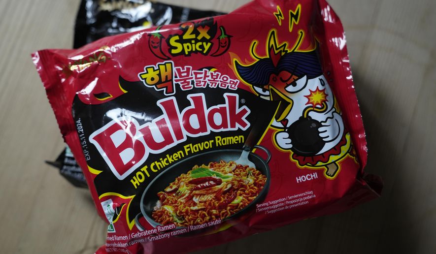 In this photo illustration two packets of Samyang noodles are pictured in London, Wednesday, June 12, 2024. Food authorities in Denmark have recalled three types of spicy instant noodle products imported from South Korea over possible risks for “acute poisoning.” (AP Photo)