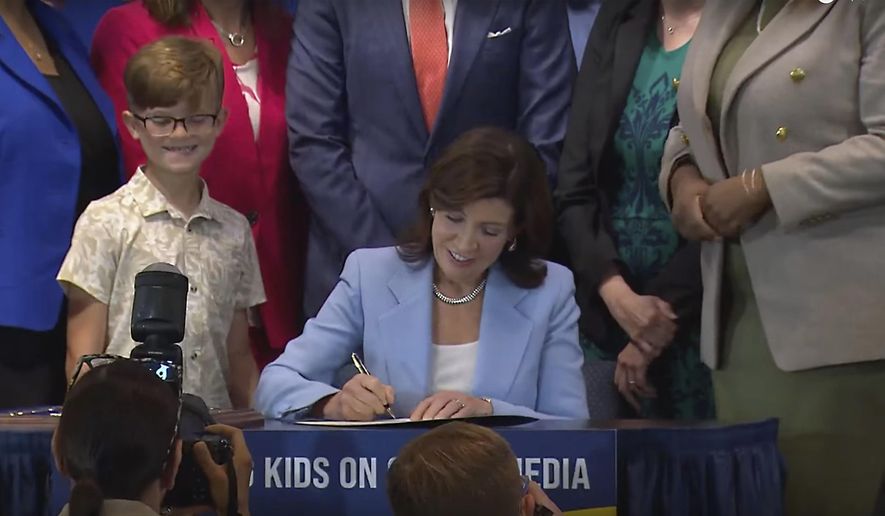 In this still image taken from video of the Office of the New York Governor, Gov. Kathy Hochul signs a bill, in New York, Thursday, June 20, 2024. Hochul signed a bill that would allow parents to block their children from getting social media posts suggested by a platform's algorithm, a move to limit feeds critics argue are addictive. (Office of the New York Governor via AP)