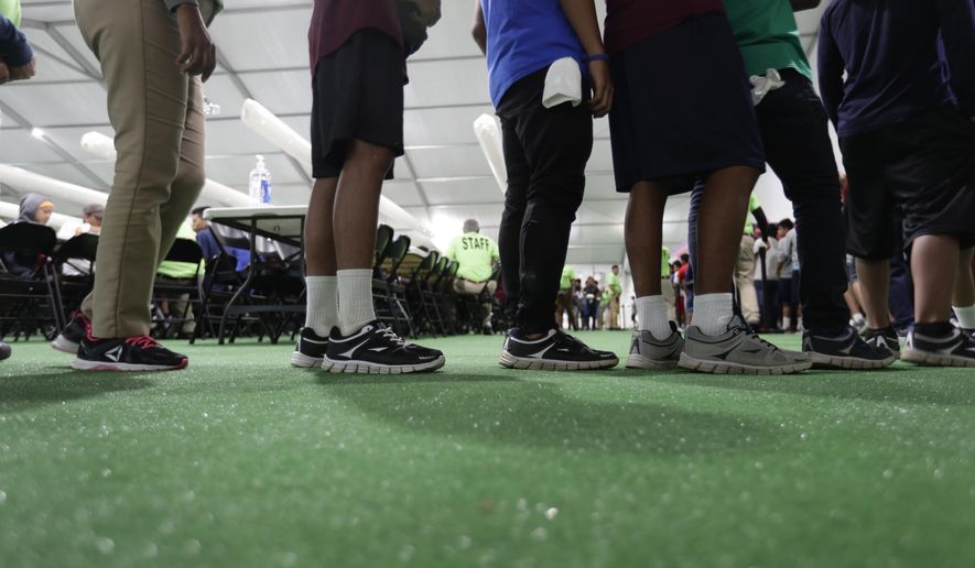 In this July 9, 2019, file photo, immigrants line up in the dinning hall at the U.S. government's newest holding center for migrant children in Carrizo Springs, Texas. For 27 years, federal courts have held special oversight over custody conditions for child migrants. The Biden administration wants a judge to partially lift those powers on Friday, June 21, 2024. (AP Photo/Eric Gay, File)