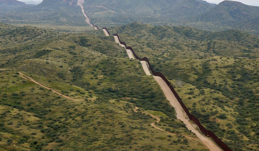 The border between the United States and Mexico, at right, cuts through the Sonoran Desert at the base of the Baboquivari Mountains, Thursday, Sept. 8, 2022, near Sasabe, Ariz. (AP Photo/Giovanna Dell'Orto, File)