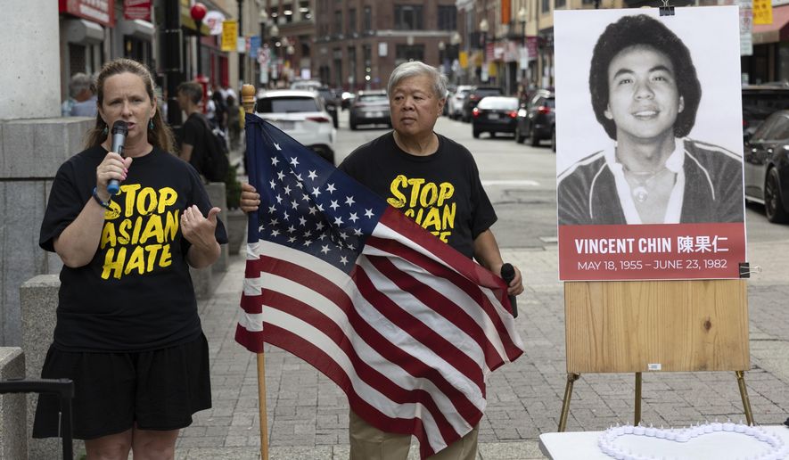 Wilson Lee holds an U.S. flag as Boston City Councilor Erin Murphy speaks during a remembrance ceremony for Vincent Chin in Chinatown, Sunday, June 23, 2024, in Boston. Over the weekend, vigils were held across the country to honor the memory of Chin, who was killed by two white men in 1982 in Detroit. (AP Photo/Michael Dwyer)