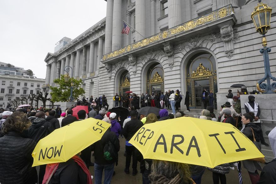 A crowd listens to speakers at a reparations rally outside of City Hall in San Francisco, on March 14, 2023. California plans to spend up to $12 million on reparations legislation under a budget signed by Gov. Gavin Newsom, marking a milestone in the state's efforts to atone for a legacy of racism and discrimination against Black Californians. (AP Photo/Jeff Chiu, File)