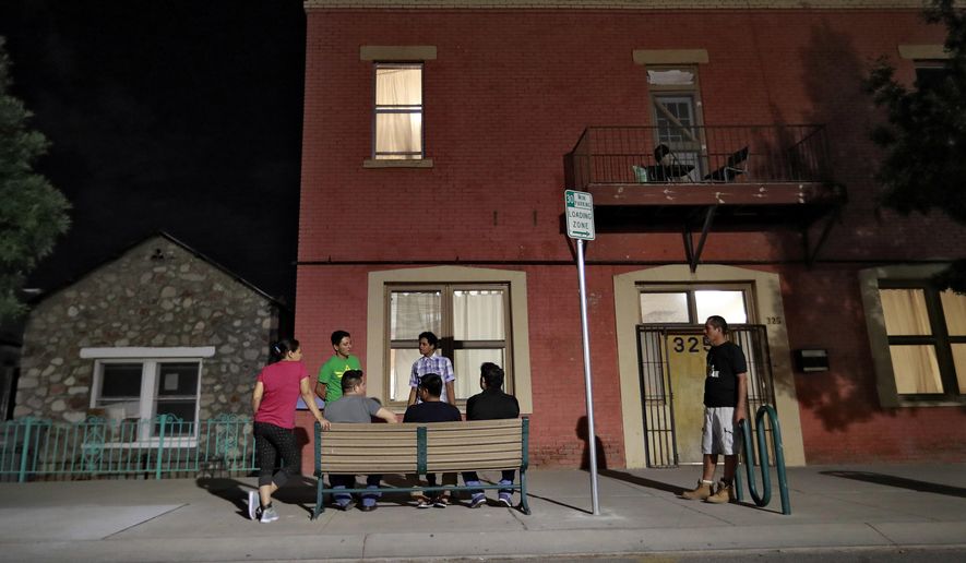 Migrant parents socialize outside the Annunciation House, June 26, 2018, in El Paso, Texas. A Texas judge ruled against the state attorney general on Tuesday, July 2, 2024, in his effort to shut down a migrant shelter in El Paso that he claimed encourages illegal migration. (AP Photo/Matt York, File)