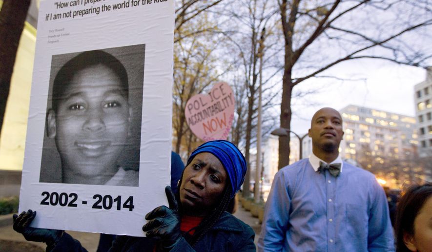 FILE - In a Monday, Dec. 1, 2014 file photo, Tomiko Shine holds up a picture of Tamir Rice during a protest in Washington, D.C. Timothy Loehmann, the Cleveland police officer who shot and killed Tamir Rice and ultimately was fired, resigned Monday, July 1, 2024, from a police department in White Sulphur Springs, W.Va. White Sulphur Mayor Kathy Glover said Loehmann had been hired as a probationary officer at the recommendation of the small town’s police chief. (AP Photo/Jose Luis Magana, File)