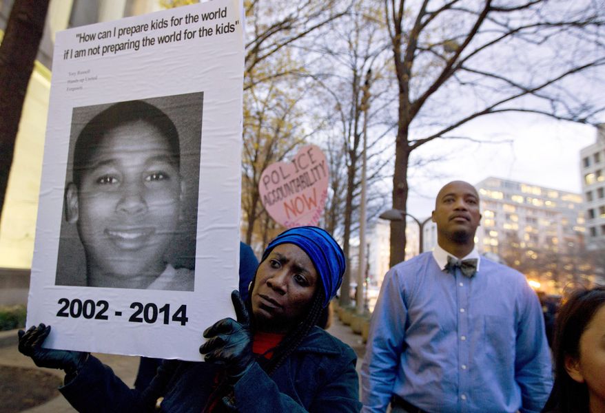 FILE - In a Monday, Dec. 1, 2014 file photo, Tomiko Shine holds up a picture of Tamir Rice during a protest in Washington, D.C. Timothy Loehmann, the Cleveland police officer who shot and killed Tamir Rice and ultimately was fired, resigned Monday, July 1, 2024, from a police department in White Sulphur Springs, W.Va. White Sulphur Mayor Kathy Glover said Loehmann had been hired as a probationary officer at the recommendation of the small town’s police chief. (AP Photo/Jose Luis Magana, File)